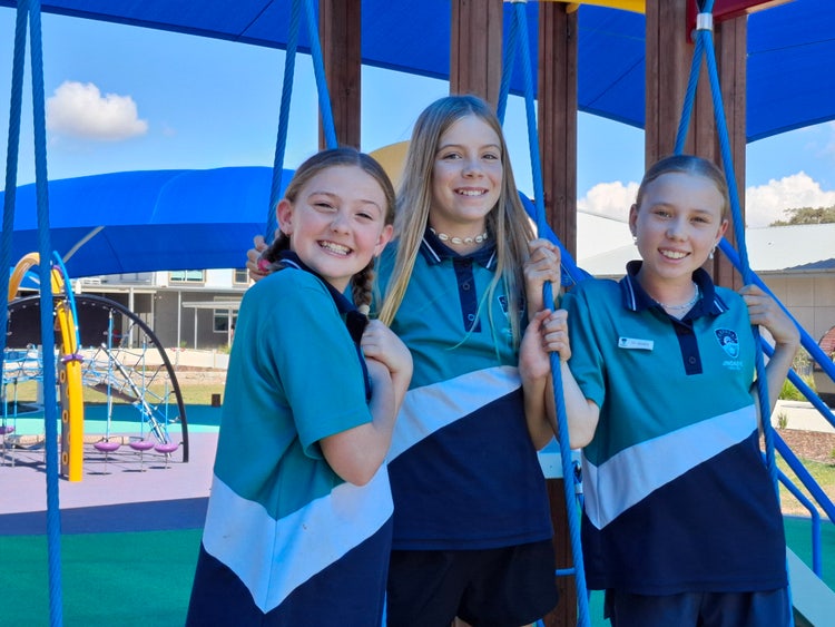 Three students smiling at the camera