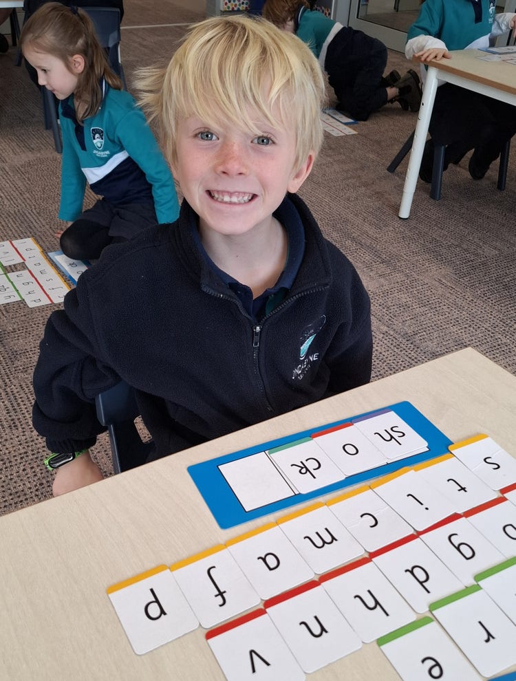 A student looking at the camera whilst working in the classroom.